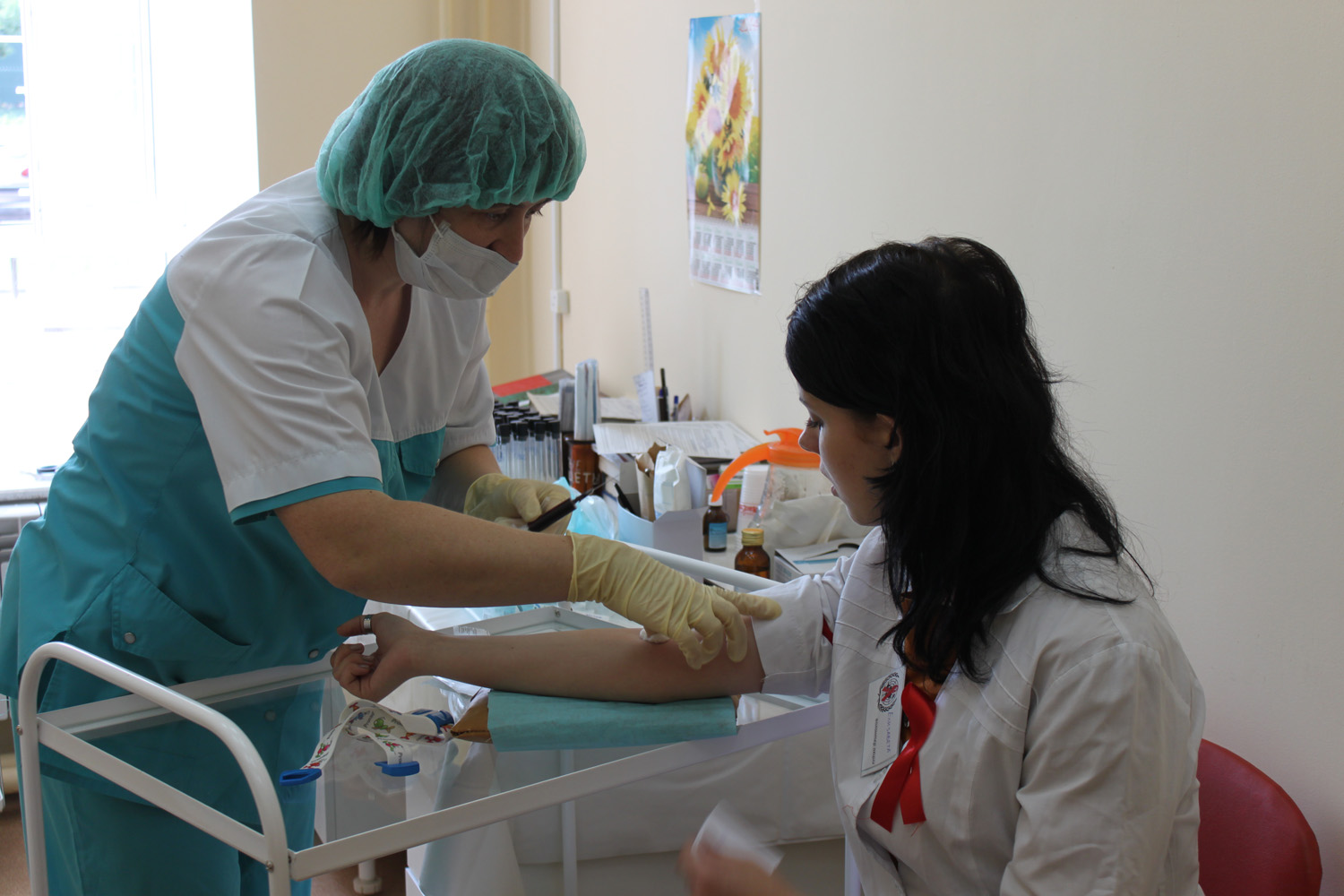 медсестра берет кровь из вены у пациентки в медицинском кабинете